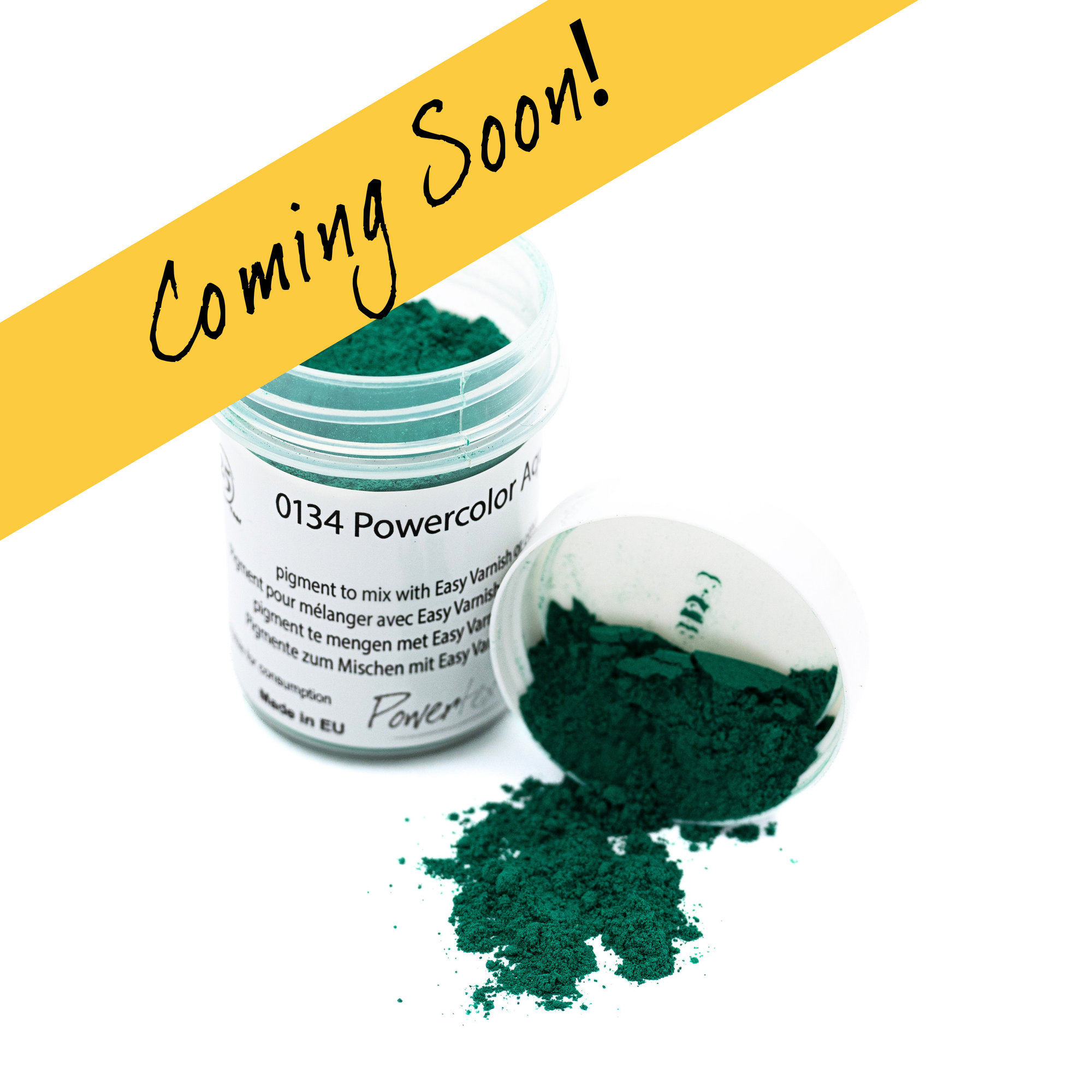 A small clear jar of pigment powder with its lid beside it and a small pile of dark green powder spilled out, on a white background with a yellow diagonal banner reading 'Coming Soon!'.